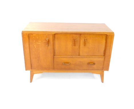 A mid 20thC G-Plan oak sideboard, with two doors above a frieze drawer, flanked to the left by a cupboard door enclosing a si