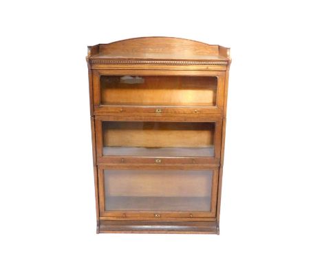 A Victorian oak Lebus bookcase, three section with a galleried top above three glass fronted up and over doors, raised on a p