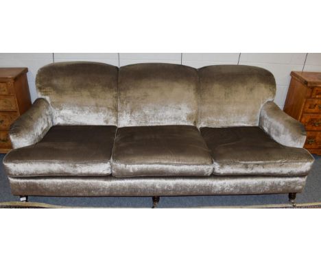 A three seater modern sofa upholstered in plush grey velvet