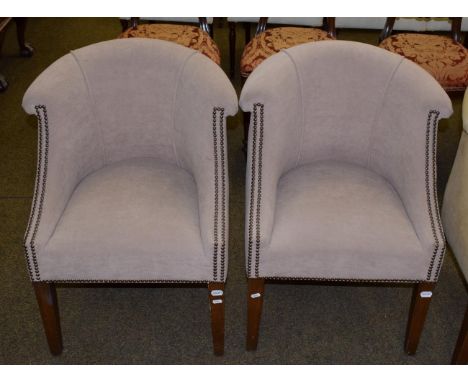 A pair of modern tub chairs upholstered in light brown fabric 