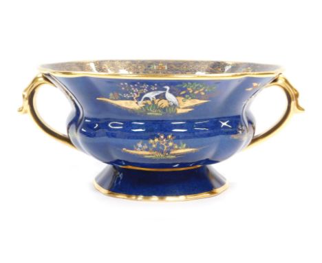 A Carltonware centrepiece, in royal blue ground with painted and applied Eastern figures, buildings and animals, with two han
