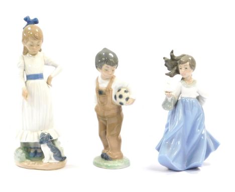 Three Nao figures, comprising girl with bird, 18cm high, a child with dog, 24cm high, and child with football, 18cm high.