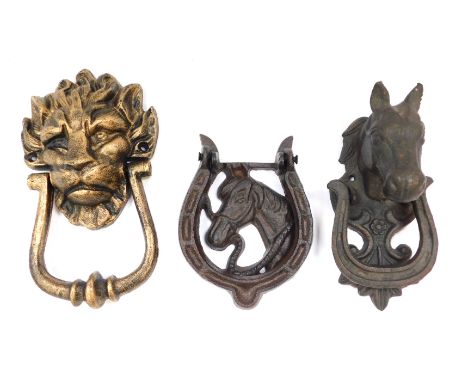 Three door knockers, comprising two horses head iron knockers and a lion mask gold coloured knocker. (3)