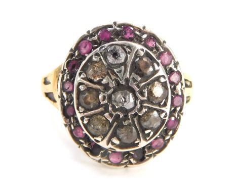 An 18ct gold dress ring, the large oval centre set with various rubies and diamonds, with etched design V splayed shoulders a