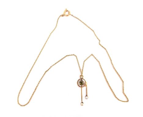 An Edwardian pendant and chain, the drop pendant with peridot and two seed pearls, 3cm high, on a fine link yellow metal neck