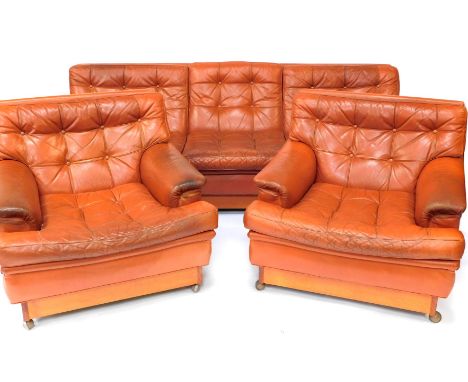 A 1960's/1970's red/orange/tan leather sofa suite by Arne Norell, comprising three seater sofa and two armchairs, each with b
