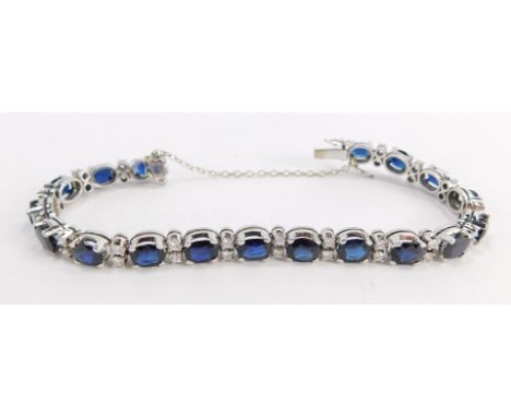 A tennis bracelet, with blue and white paste stones and safety chain, white metal unmarked, clasp stamped 1.43, 20cm long ove