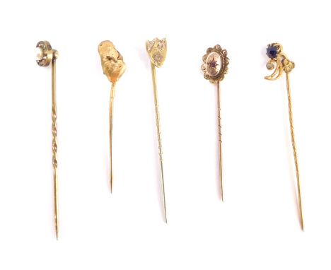 Five stick pins, comprising a shield crested top pin, golden nugget design pin, various others, three stamped 9ct, others unm