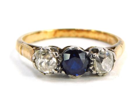A sapphire and diamond three stone ring, the round brilliant cut sapphire in claw setting, measuring 4.8mm x 3.6mm, flanked b