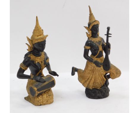 A pair of Thai inspired metal figures, depicting figures playing musical instruments, with gilt highlights, 20cm and 22cm hig