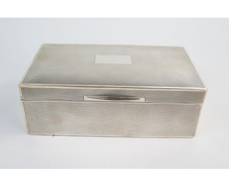 An early 20th Century silver cigarette box, of rectangular form, engine turned decoration with blank panel, London 1928, Fran