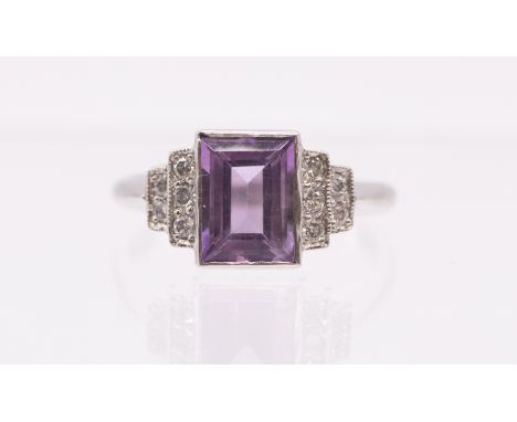 An amethyst and diamond platinum ring, the centre rectangular cut light purple amethyst measuring approx 8x6mm, rub over box 