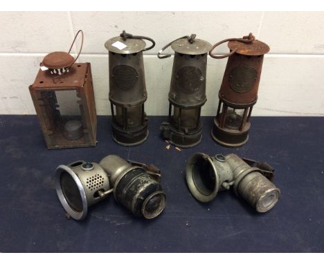  Two similar train lamps, a rectangular shaped lamp, two Eccles miners lamps, and another Eccles & Manchester miners lamp for