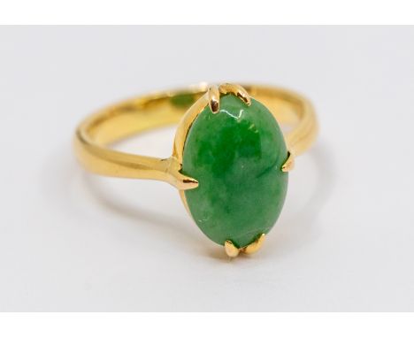 A jade and yellow metal dress ring, comprising an oval jadeite approx 10 x 7mm, claw set, to a band with nipped shoulders, Ch