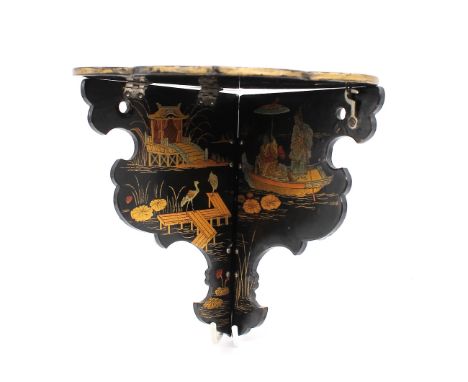 A 20th century Japanese lacquered foldable corner shelf with gilt chinoiseries design.