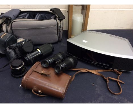 Bose CD player, Cannon camera with lenses, pair of binoculars and a modern lantern.