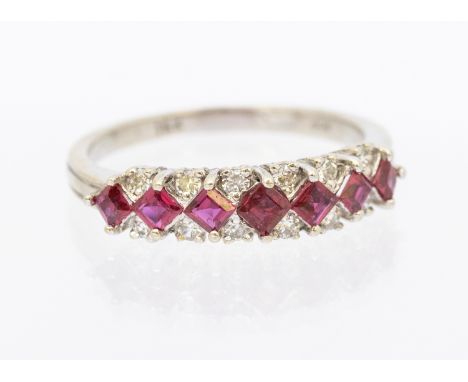 A ruby and diamond 18ct white gold half hoop design ring set with 12 brilliant cut diamonds with seven princess cut red stone