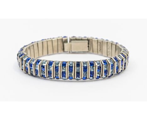 A vintage paste set blue stone white metal bracelet by Schreiber & Hiller, comprising channel set bars of dark and light blue