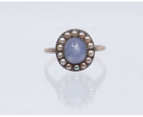 An early 20th century star sapphire and pearl set 9ct gold cluster ring, comprising a central oval star sapphire approx 9 x 7