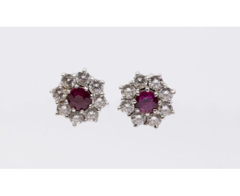 A pair of ruby and diamond 18ct white gold cluster earrings, the centre set with a round mixed cut ruby, approx 4mm, within a