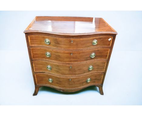 An early 19th century oak serpentine fronted gentleman's dressing chest, having four drawer front, the first having various c