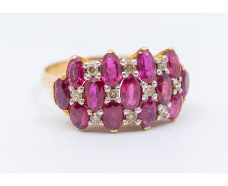 A ruby and diamond 9ct ring, comprising three rows of oval mixed cut rubies, each approx 3 x 4mm, with small diamond accents,