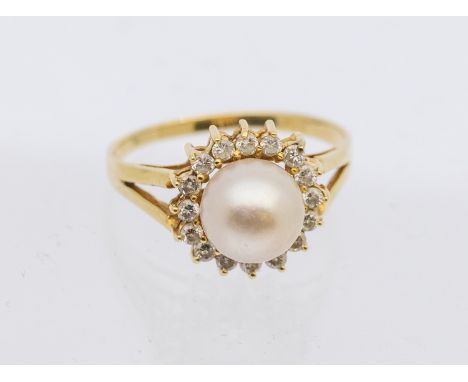 A pearl and diamond set 14ct gold cluster ring, comprising a cultured pearl to the centre within a border of small claw set d