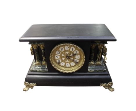 A late 19th/early 20th century slate style ebonised wooden cased mantle clock, having marble style and column style support d