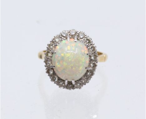 An opal cluster and diamond 18ct gold cluster ring, comprising an oval claw set opal approx 12 x 9mm, with orange and green p