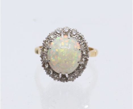 An opal cluster and diamond 18ct gold cluster ring, comprising an oval claw set opal approx 12 x 9mm, with orange and green p