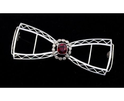 A 1950's ruby and diamond bow brooch, comprising a central cushion cut ruby 5x6mm, rub over set within an open collet set bor