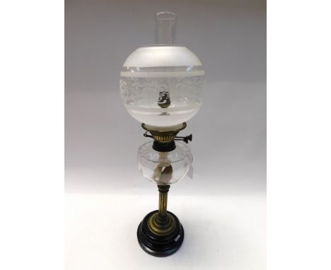 A Victorian T. Rowatt brass oil lamp with clear glass oil chamber and a glass flue and possible replacement glass shade.