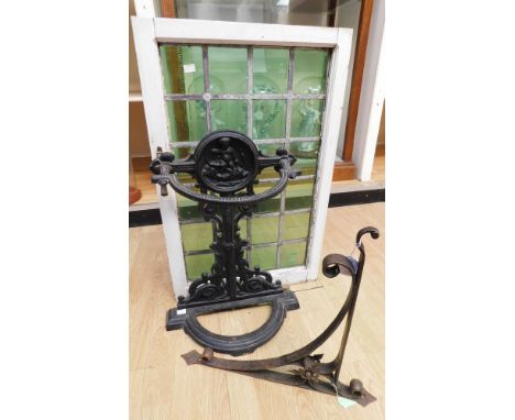 Early 20th century cast iron stick stand, 19th century cast iron hanging bracket and green stained glass window pane (3)