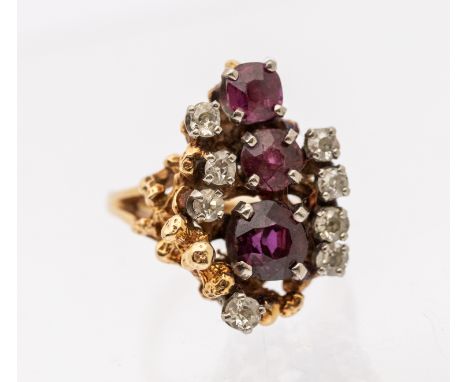 A Retro ruby and diamond gold set cluster ring, comprising a central round of claw set graduated round mixed cut rubies, the 