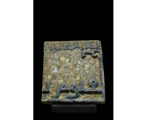 Kashan, Ca. 1100-1200 AD. A rectangular-shaped pottery tile with a brown ground decorated with a dotted and vegetal motifs an