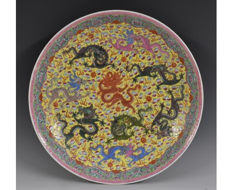 A Chinese circular charger, painted in the famille jaune pallete with dragons on a yellow ground, trellis border, 33.5cm diam