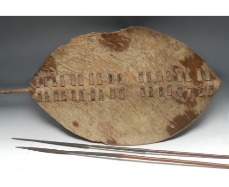 Tribal Art - a Zulu hide shield, of typical form, the rod 112cm long, South Africa, c. 1900; two assegai spears, (2), [3] 