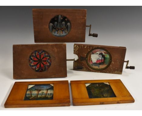 A late 19th century novelty mechanical magic lantern slide, The Mouse Eating Man, cranking handle to side, 18cm wide; others,