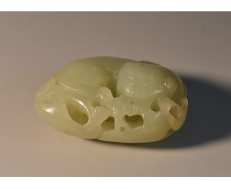 A Chinese celadon jade carving, of a stylized beast amongst blossoming prunus, 5cm wide 