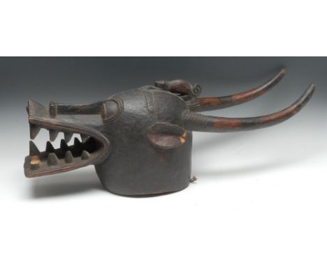 Tribal Art - a Bambara hyena mask, stylised features, pronounced snout showing teeth, crested by long curved horns, 76.5cm lo