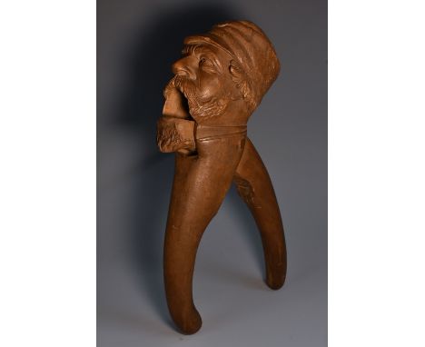A Black Forest lever-action novelty nutcracker, carved as a bearded man wearing a cap, 20.5cm long, c.1900