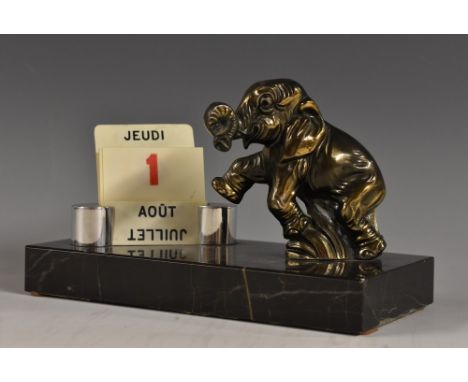 An Art Deco desk calendar, with a standing Elephant calf rearing, curled trunk, beside a manual day and month display in Fren