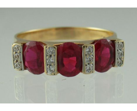 An 18ct gold three stone ruby and diamond ring. The three oval rubies separated by three rows of three diamonds.  Together wi