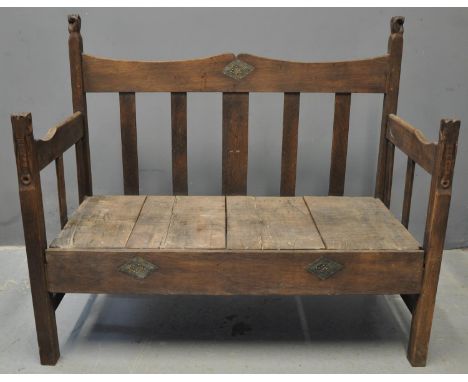 West African stained hardwood slat backed settle, the open arm sides with elephant head terminals and fist terminals to the b