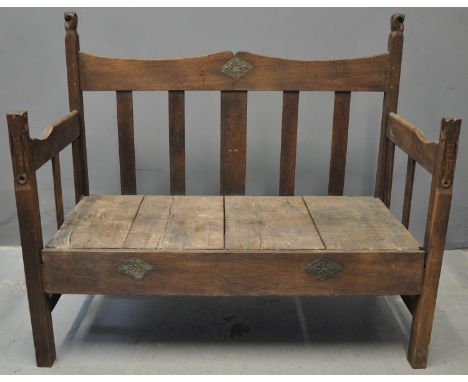 West African stained hardwood slat backed settle, the open arm sides with elephant head terminals and fist terminals to the b