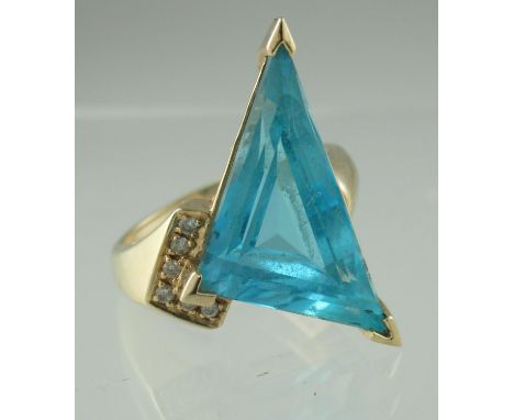 14ct gold blue topaz and diamond ring. The triangle cut blue topaz having one diamond set shoulder. Ring size M&1/2. Approx w