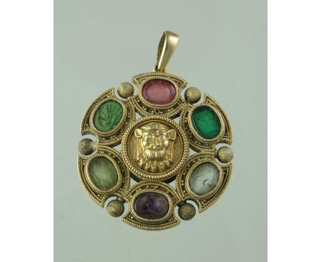 A 19th century circular yellow metal pendant decorated with a raised and engraved lion's head to the centre surrounded by six