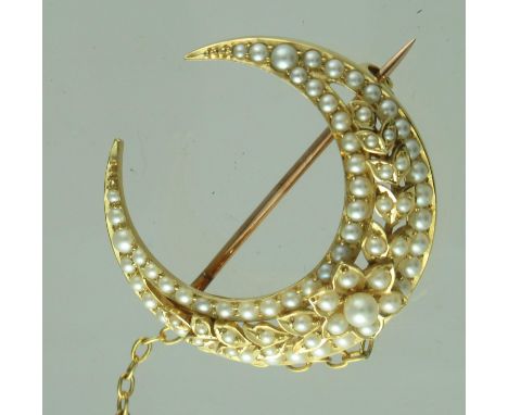Pearl set crescent brooch with pearl set floral wreath detail.  Set in yellow metal.  Diameter 32mm.  Approximate weight 10.4