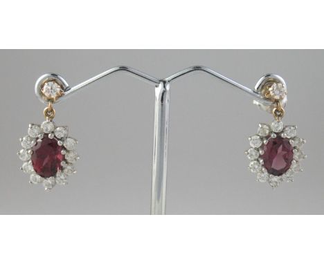 A pair of oval ruby and diamond drop earrings set in 9ct gold.  Length of drop 21mm. Drop approx 14 x 11 mm. Approx weight 3 