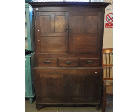 Early 19th Century Welsh oak press cupboard, having moulded cornice above two blind panelled doors, the interior revealing on